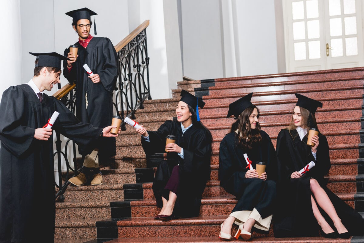 cheerful group of students in graduation gowns sit 2023 11 27 05 00 33 utc