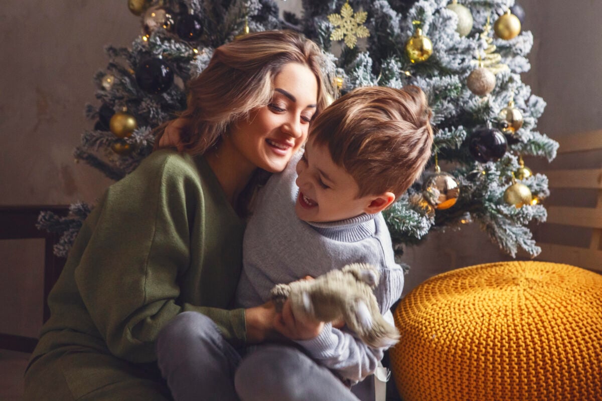 cute little boy unpacking christmas gift with moth 2023 11 27 05 16 10 utc